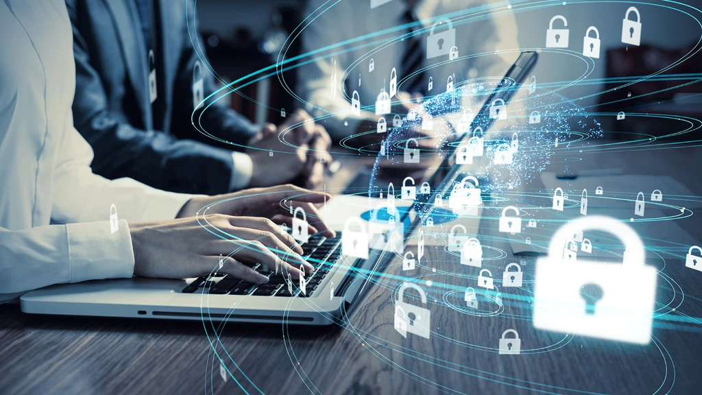 Hands on laptop with security icons overlaying the image